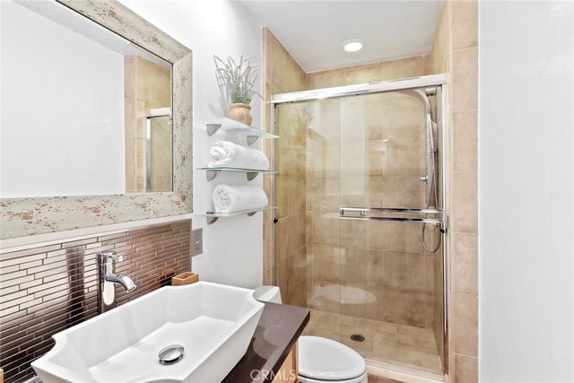 a bathroom with a sink vanity granite toilet and shower