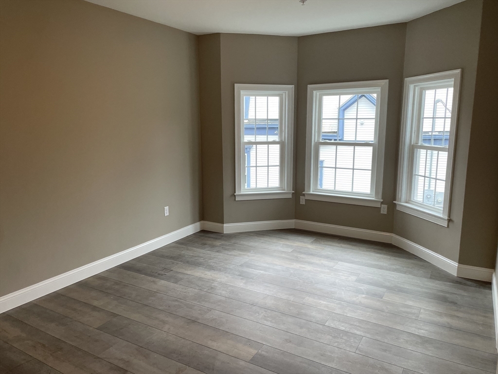1 Brattle Street, Unit 1 Worcester, MA 01606 - Photo 18 of 21 an empty room with wooden floor and windows