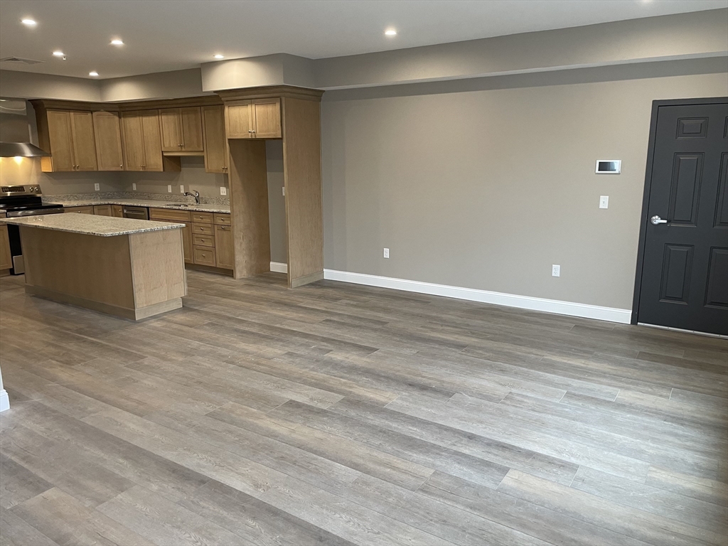 1 Brattle Street, Unit 1 Worcester, MA 01606 - Photo 4 of 21 a large kitchen with stainless steel appliances granite countertop a stove and a refrigerator