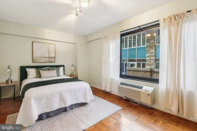 a bedroom with a bed and wooden floor
