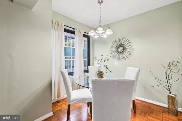 a dining room with furniture a chandelier and wooden floor