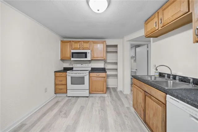 a kitchen with stainless steel appliances granite countertop a stove a sink and a microwave