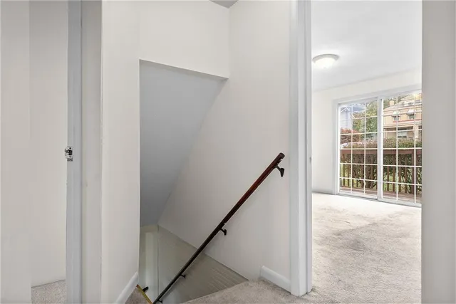 a view of a hallway with wooden floor and stairs
