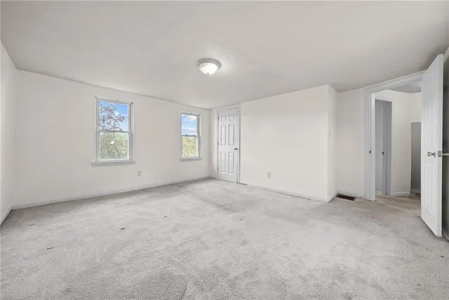 an empty room with windows and closet