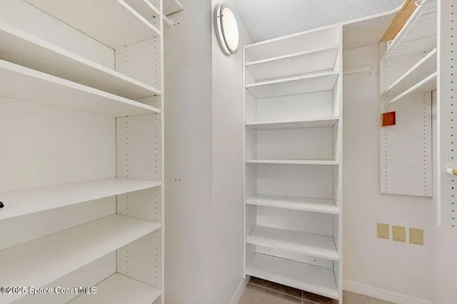 a view of walk in closet with empty racks