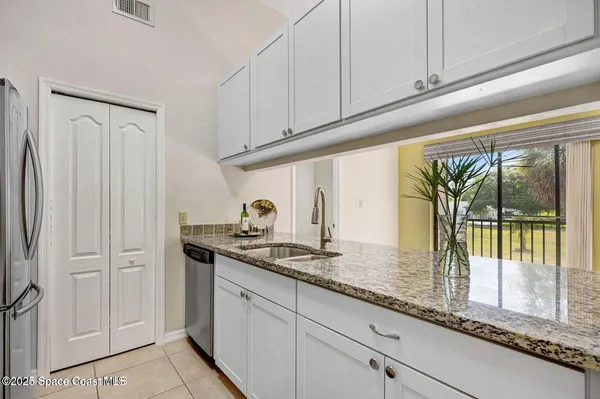 a kitchen with granite countertop a sink and cabinets