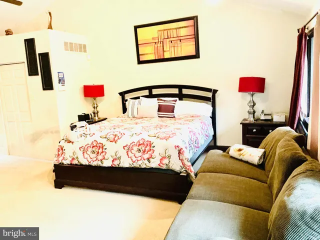 a bedroom with a bed and a painting on the wall