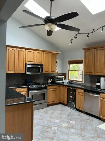 a large kitchen with stainless steel appliances granite countertop a stove and a sink