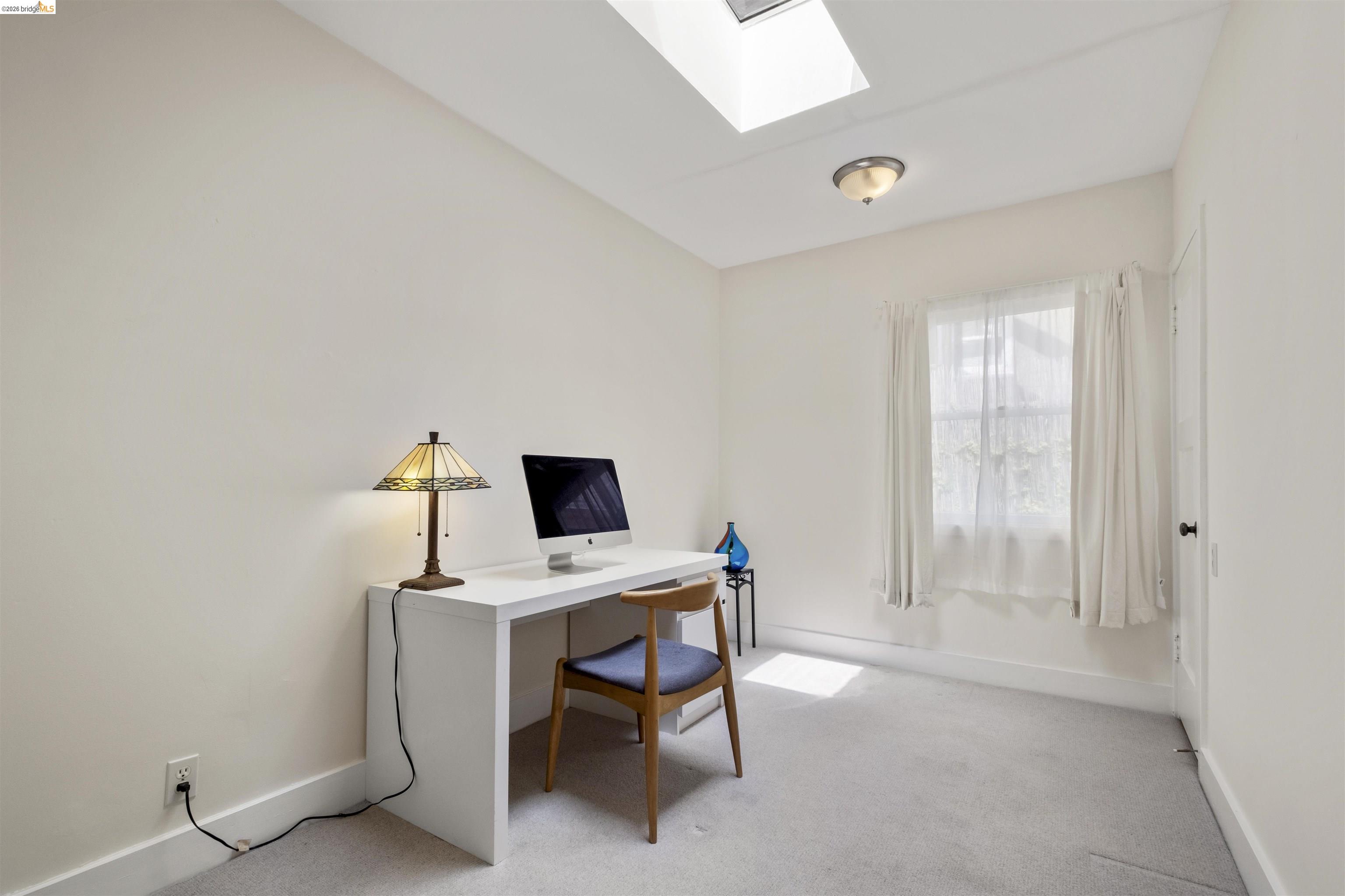 2444 Virginia Street, Unit B Berkeley, CA 94709 - Photo 33 of 39 Neutral-toned room featuring a skylight, window, and ceiling-mounted light fixture