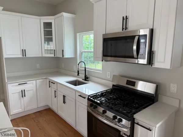 a kitchen with stainless steel appliances granite countertop a sink stove top oven and cabinets