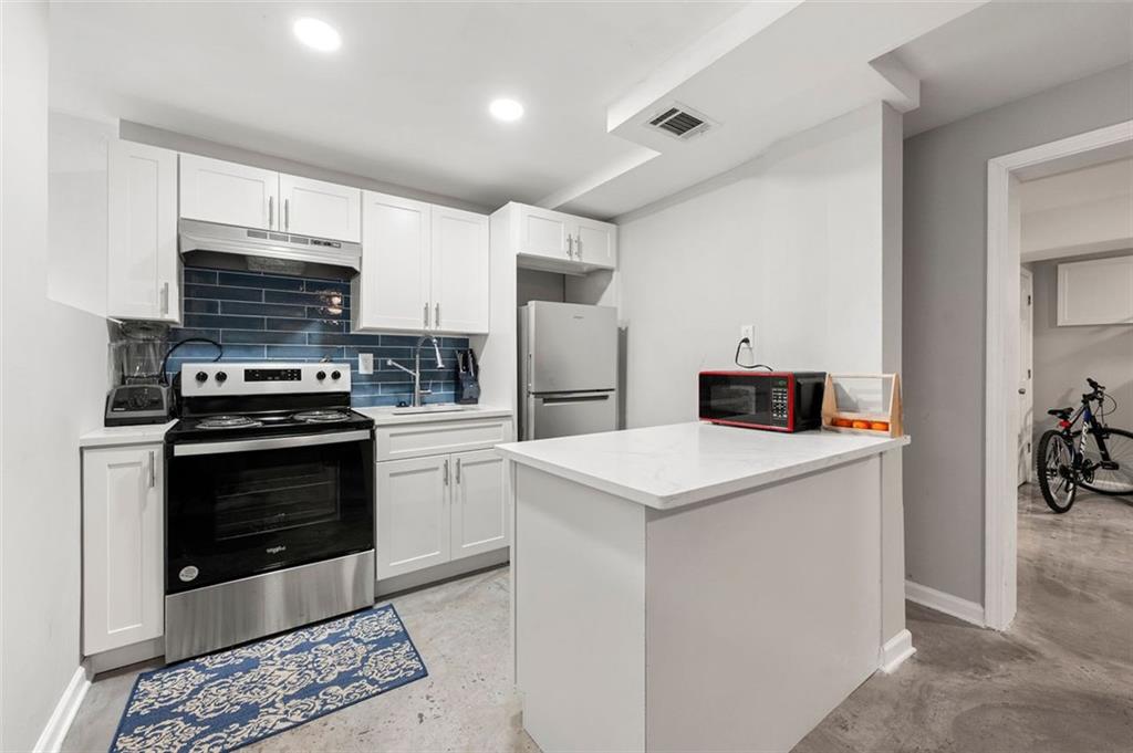 653 Somerset Terrace Northeast, Unit 3 Atlanta, GA 30306 - Photo 7 of 16 a kitchen with stainless steel appliances a stove microwave and a refrigerator