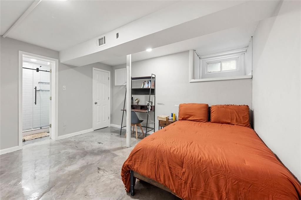 653 Somerset Terrace Northeast, Unit 3 Atlanta, GA 30306 - Photo 9 of 16 a bed sitting in a spacious bedroom chandelier and a dresser