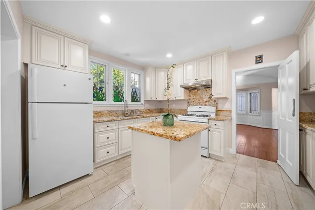 a kitchen with white cabinets and white appliances