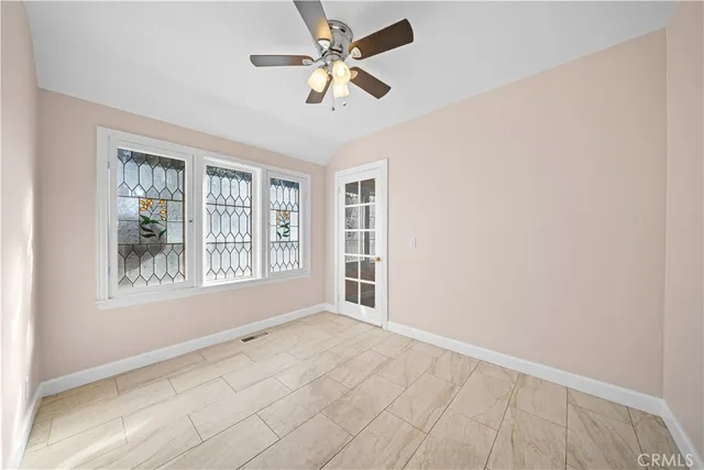 an empty room with windows and fan