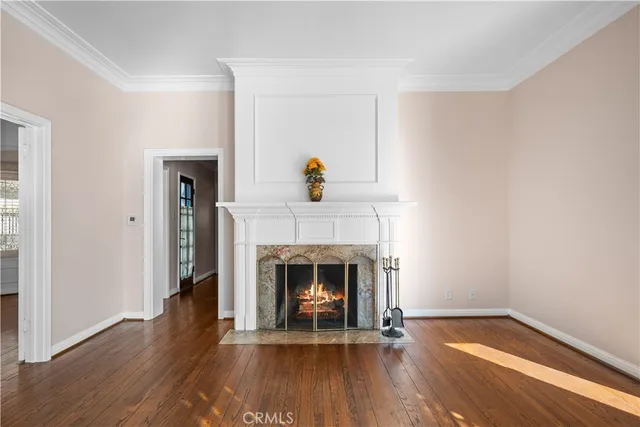 a living room with wooden floor and a fireplace