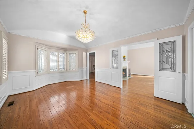 a view of empty room with wooden floor and window