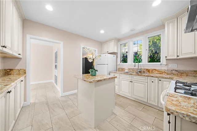 a kitchen with granite countertop cabinets a sink a window and stainless steel appliances