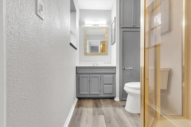 a bathroom with a granite countertop toilet and a sink