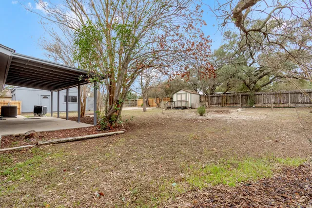 a view of a backyard with large trees