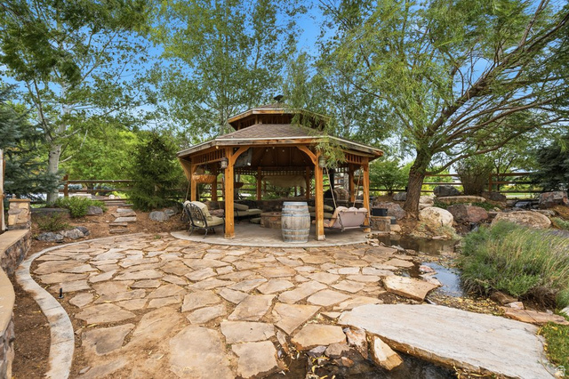 672 Perry Hollow Drive Mapleton, UT 84664 - Photo 98 of 106 Expansive flagstone patio with a hexagonal wooden gazebo featuring a shingle roof