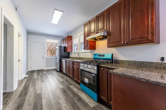 a kitchen with stainless steel appliances granite countertop wooden cabinets a stove top oven a sink and dishwasher
