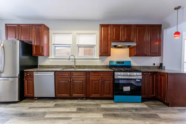 a kitchen with granite countertop wooden cabinets a sink and a stove