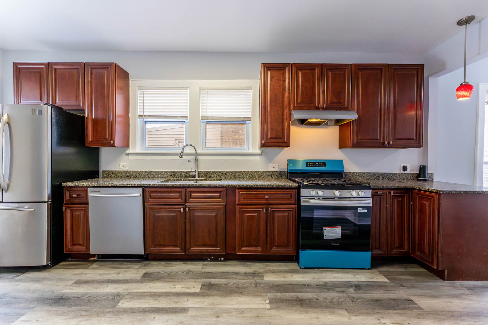 7427 South Perry Avenue Chicago, IL 60621 - Photo 6 of 19 a kitchen with granite countertop wooden cabinets a sink and a stove