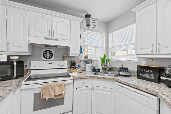 a kitchen with white cabinets and a stove