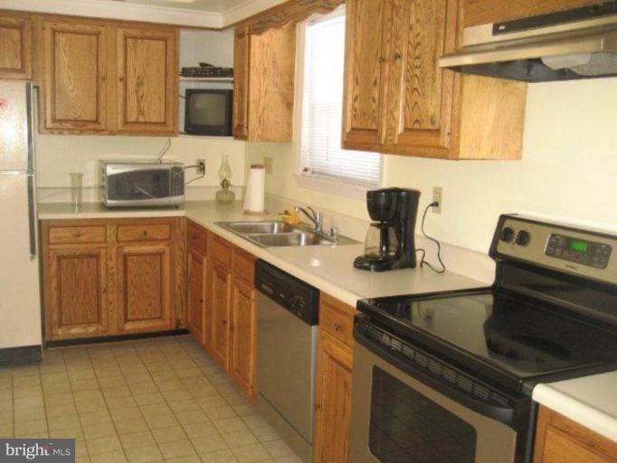 3725 Briars Road Olney, MD 20832 - Photo 4 of 12 a kitchen with stainless steel appliances a sink stove and cabinets