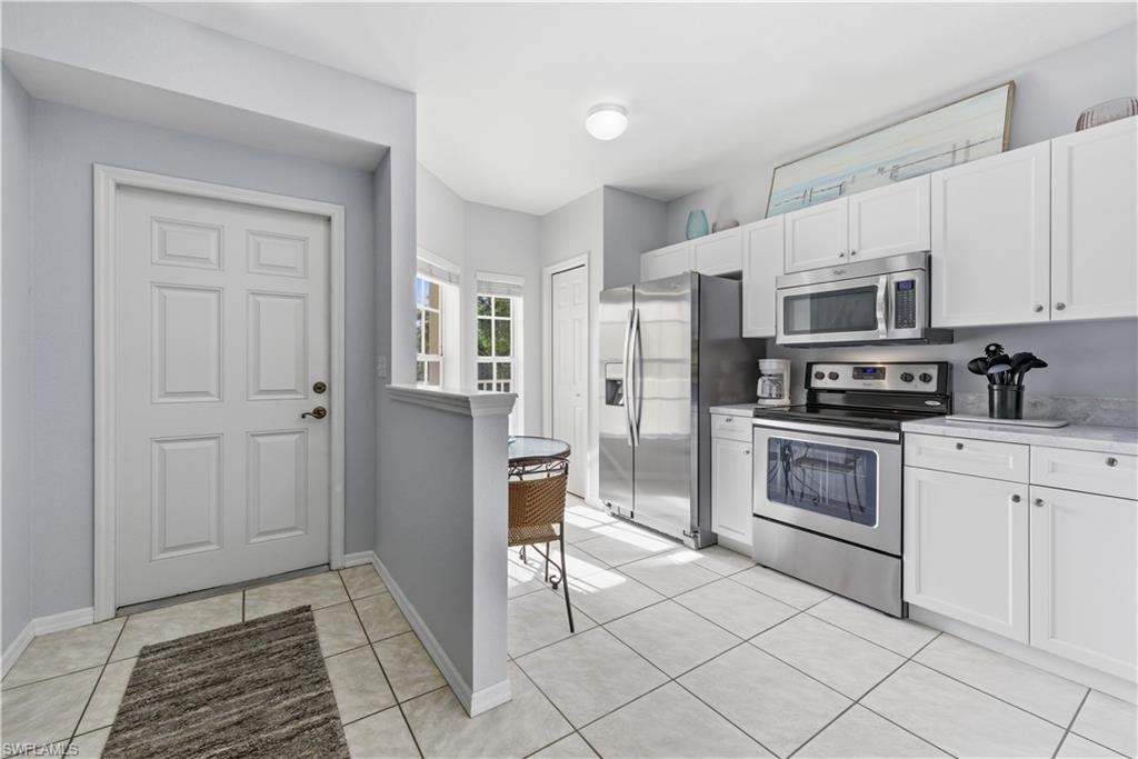 9175 Celeste Drive, Unit 204 Naples, FL 34113 - Photo 4 of 50 Entry and bright modern coastal kitchen
