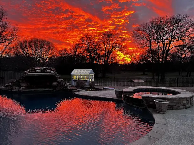 a backyard of a house with fire pit and trees