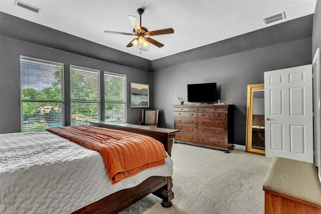 a bedroom with a bed a flat screen tv and a chandelier