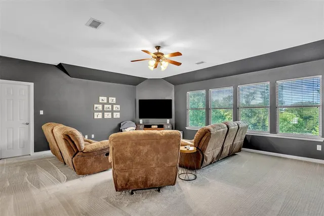 a living room with furniture a flat screen tv and a large window