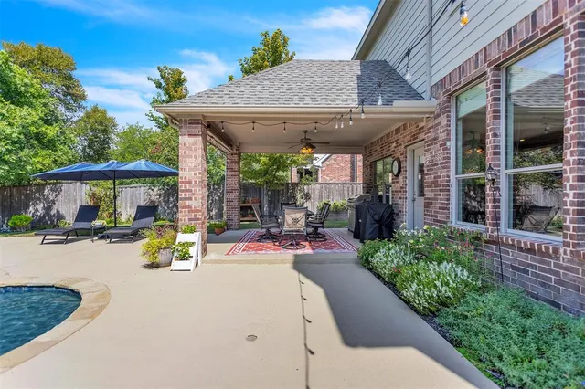 a view of a patio with table and chairs under an umbrella