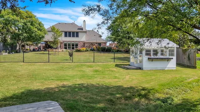 a view of a house with a big yard and large trees