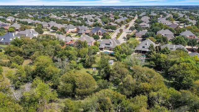 an aerial view of residential houses with outdoor space and trees