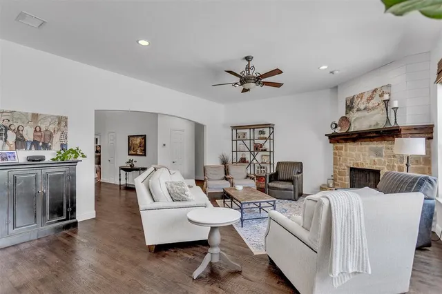 a living room with furniture a fireplace and a kitchen view
