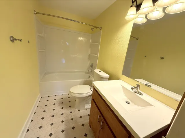 a bathroom with a sink mirror vanity and toilet