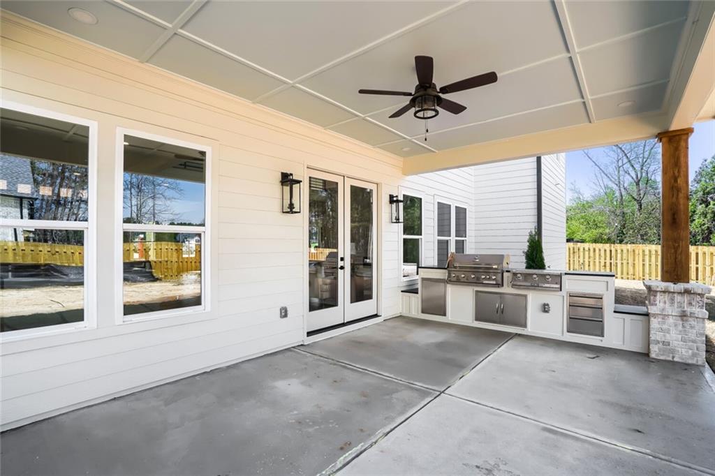 932 Cooper Road Loganville, GA 30052 - Photo 36 of 36 a large white kitchen with granite countertop a large window and stainless steel appliances