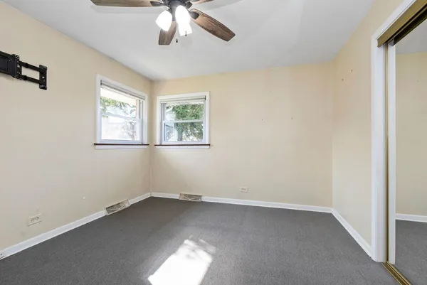 an empty room with a window and a fan