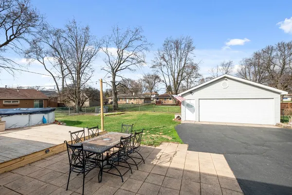 a view of a patio with a table and chairs and couches with wooden floor and fence