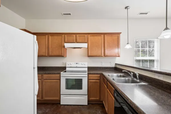 a kitchen with stainless steel appliances granite countertop a sink stove and cabinets