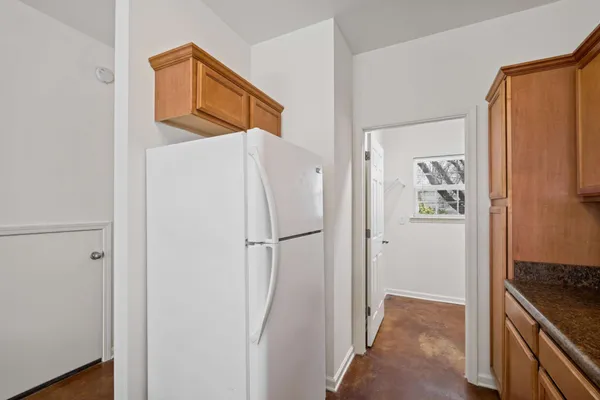 a white refrigerator freezer and a stove sitting inside of a kitchen