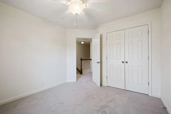 an empty room with fan and entrance
