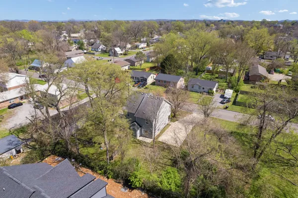 an aerial view of a house with a yard and large tree