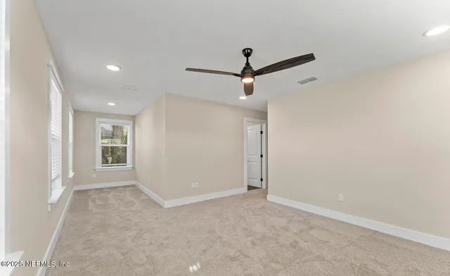 an empty room with a ceiling fan and window
