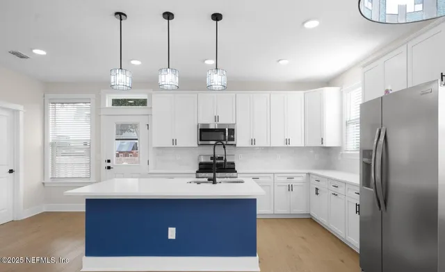 a kitchen with kitchen island a sink stainless steel appliances and cabinets