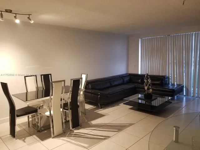 a living room with furniture a piano and wooden floor