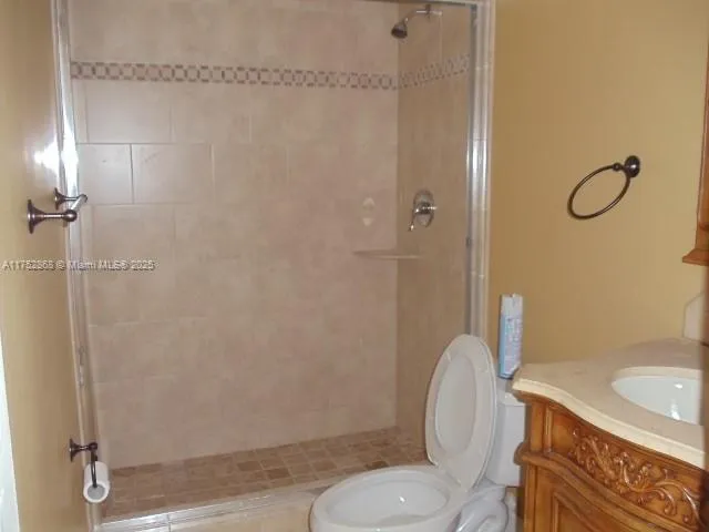 a bathroom with a granite countertop sink a toilet and a mirror
