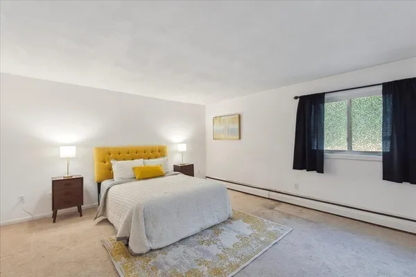 a bedroom with a bed and a large window